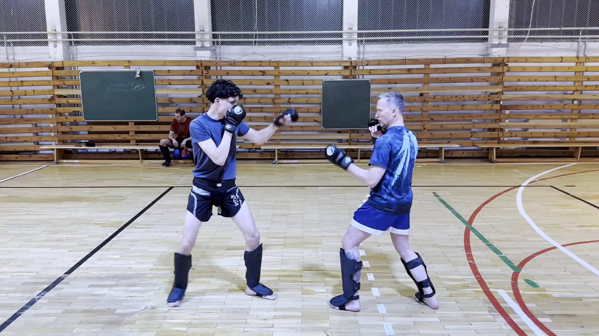 Sparring mit Handschuhen und Schienbeinschonern in der Halle