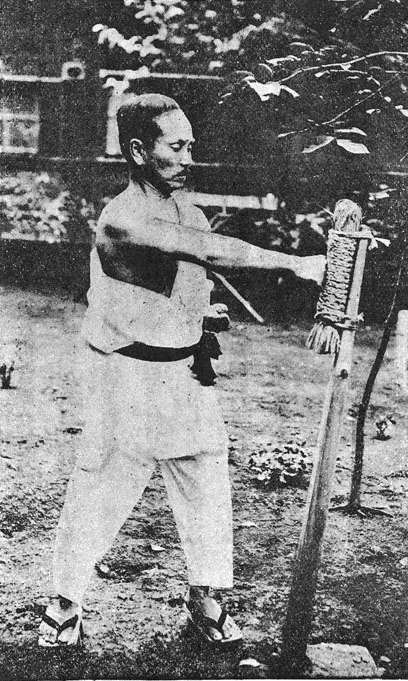 Gichin Funakoshi beim Training am Makiwara (historisches Foto, 1925)